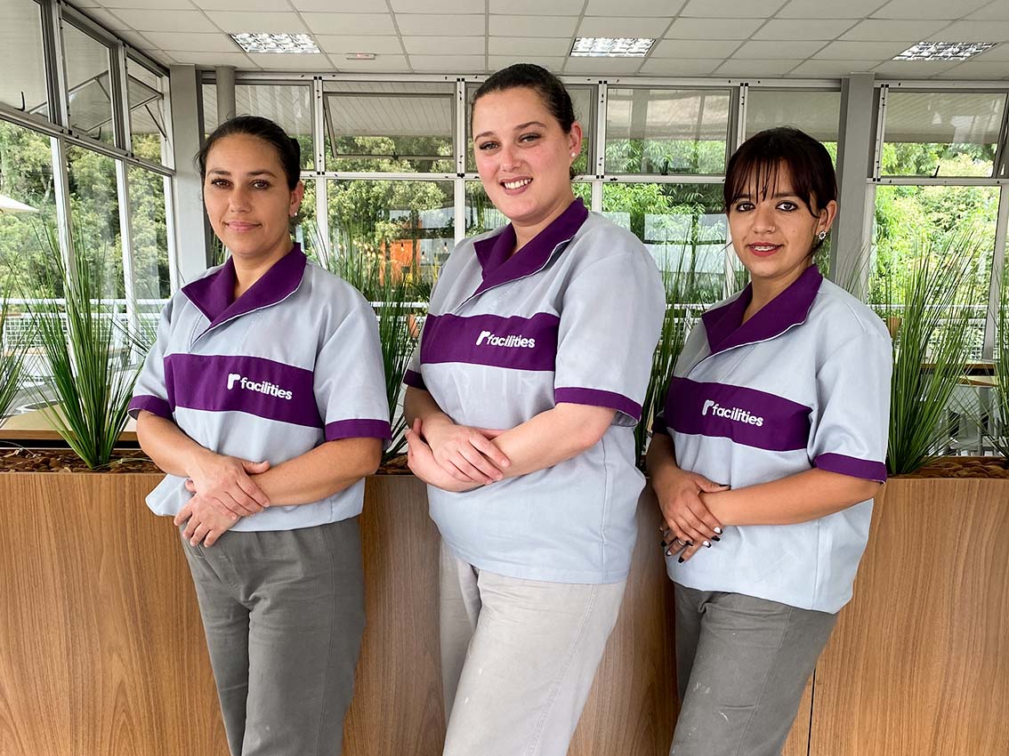 Equipe uniformizada da R Facilities posando em ambiente corporativo, representando excelência e padronização na prestação de serviços terceirizados